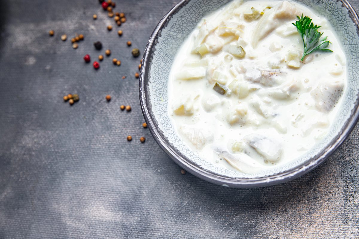 Herring pieces in a sour cream sauce in a bowl