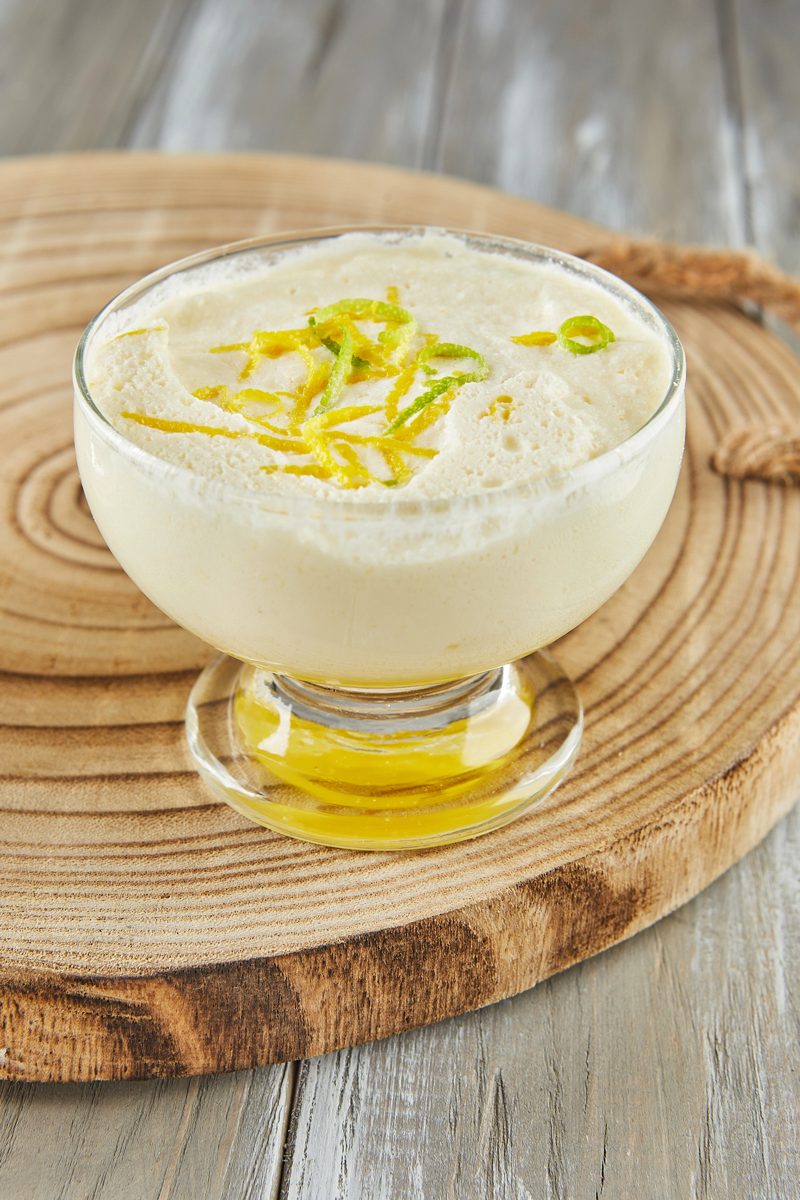 Lemon mousse in a glass dessert cup topped with lemon zest