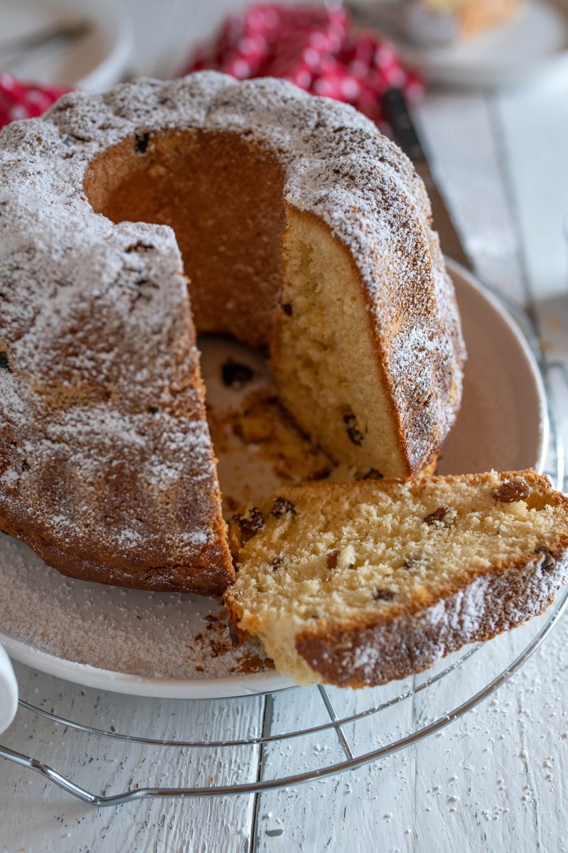 Yeast kugelhopf with raisins dusted with powdered sugar, one slice cut