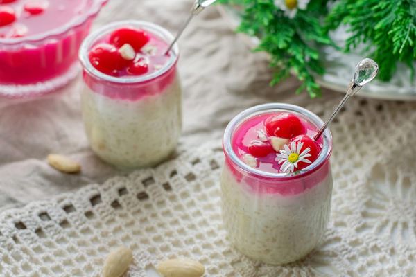 Risalamande rice pudding with almonds and red cherry sauce in glasses