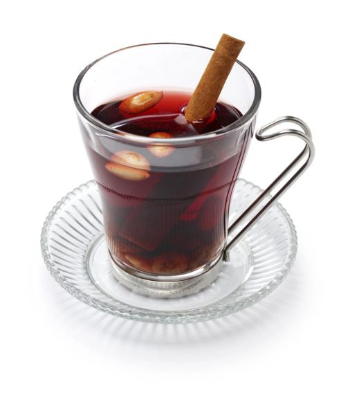 Glass mug of Danish gløgg mulled wine with a cinnamon stick