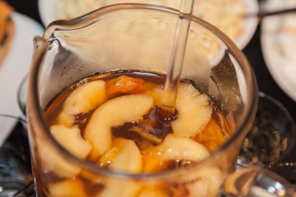 Jug and glass of dried fruit compote with pieces of fruit