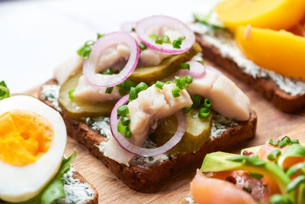 Open-faced rye bread sandwiches with herring, red onion and boiled egg