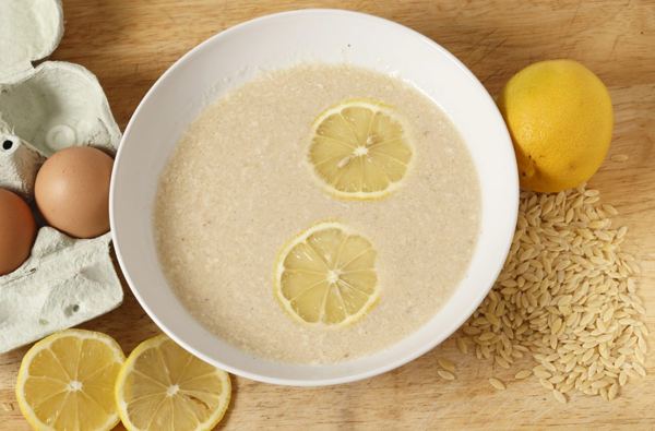 Bowl of egg and lemon broth with lemon slices