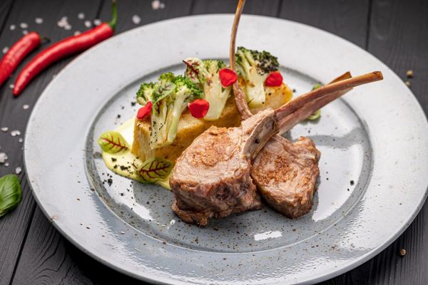 Roast rack of lamb with potato gratin on a grey plate
