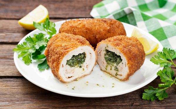 Chicken Kyiv cut open to show the herb butter filling