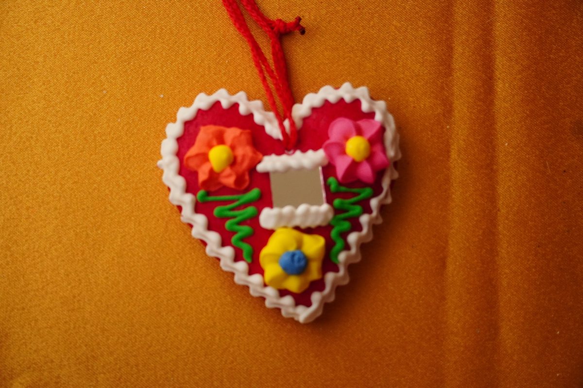 Red licitar heart decorated with white icing and a small mirror