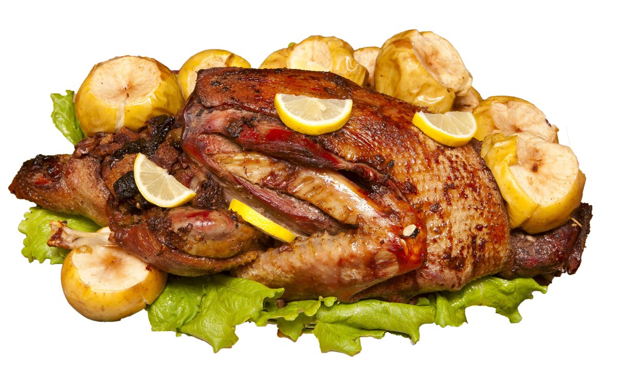 Roast duck with apples and lemon on a platter